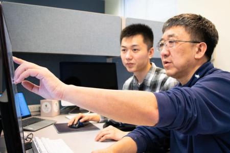 An image of Ying Xu and student at a computer